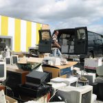 piles of old computers and electronics get loaded into a van